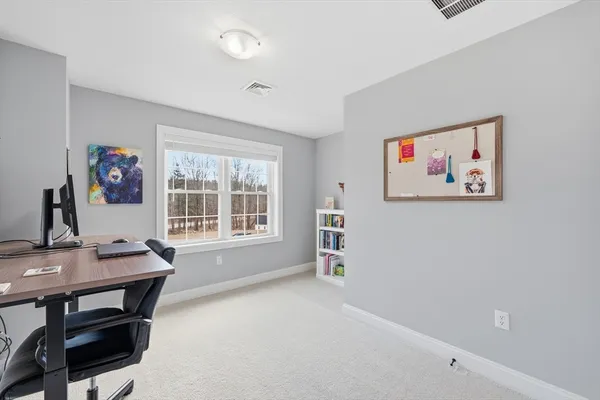 a view of a workspace with furniture and a window