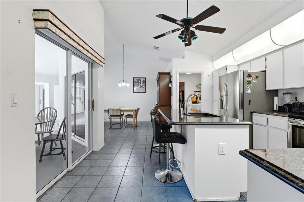 4355 West Justice Court Homosassa, FL 34446 - Photo 5 of 30 a kitchen with stainless steel appliances a refrigerator a stove a sink a dining table and chairs with wooden floor