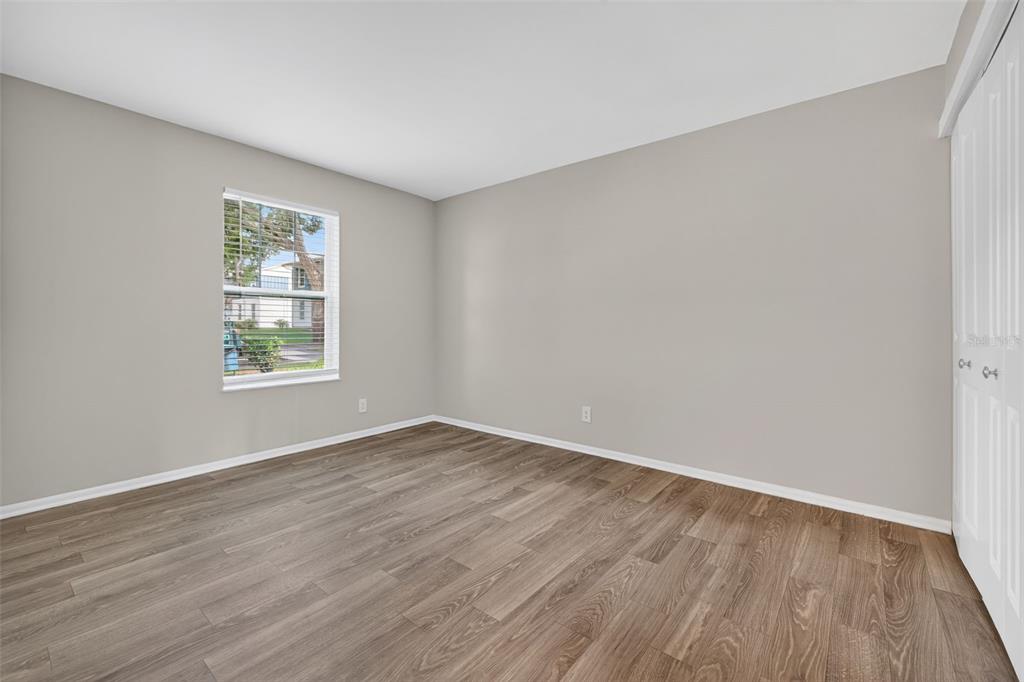 612 Bass Court, Unit 620B Dunedin, FL 34698 - Photo 13 of 32 a view of an empty room with wooden floor and a window