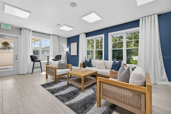 a living room with furniture and large windows