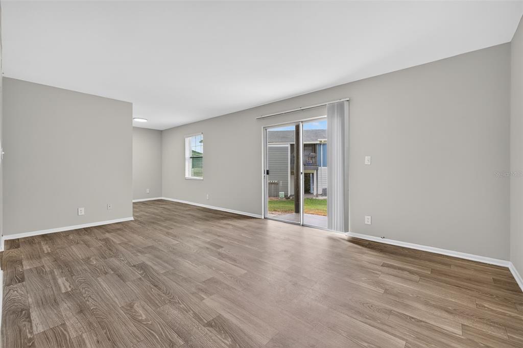 612 Bass Court, Unit 620B Dunedin, FL 34698 - Photo 3 of 32 a view of an empty room with wooden floor and a window