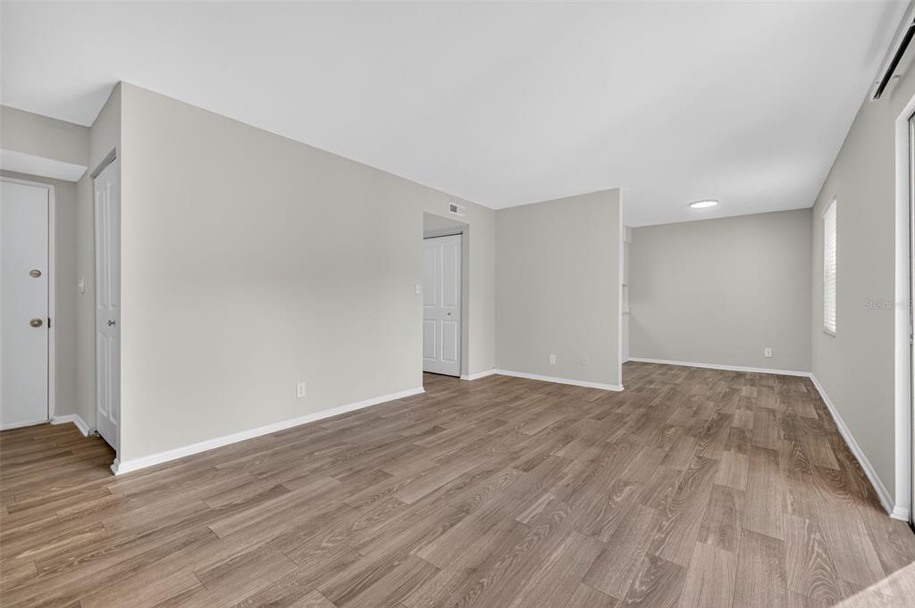 612 Bass Court, Unit 620B Dunedin, FL 34698 - Photo 4 of 32 a view of an empty room with wooden floor and closet
