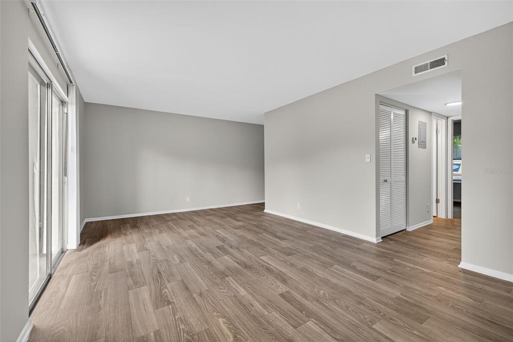 612 Bass Court, Unit 620B Dunedin, FL 34698 - Photo 5 of 32 a view of an empty room with wooden floor and a window