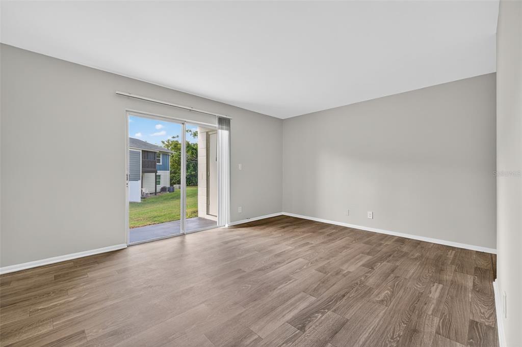 612 Bass Court, Unit 620B Dunedin, FL 34698 - Photo 6 of 32 a view of an empty room with wooden floor and a window