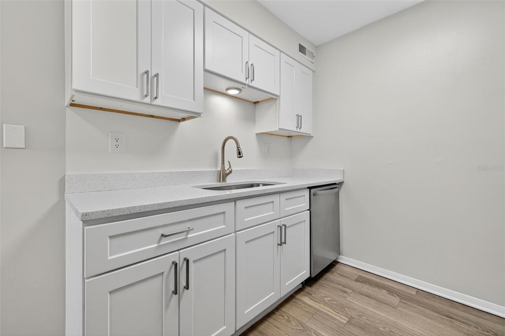 612 Bass Court, Unit 620B Dunedin, FL 34698 - Photo 8 of 32 a kitchen with white cabinets and a sink