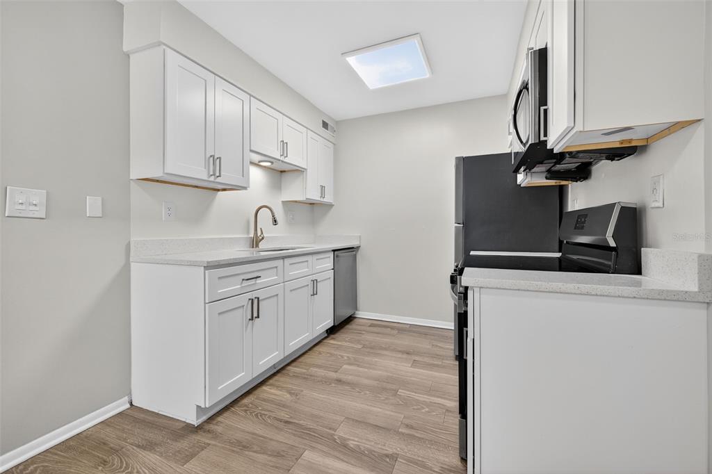 612 Bass Court, Unit 620B Dunedin, FL 34698 - Photo 10 of 32 a kitchen with cabinets stainless steel appliances and a sink
