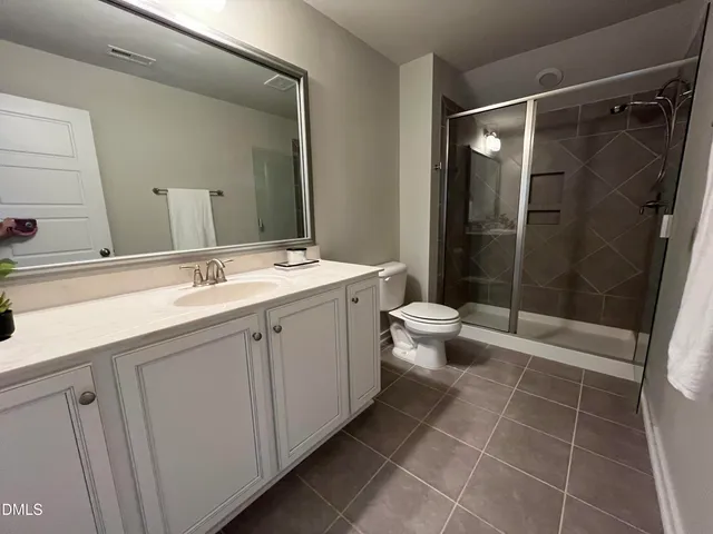 a bathroom with a double vanity sink mirror and toilet