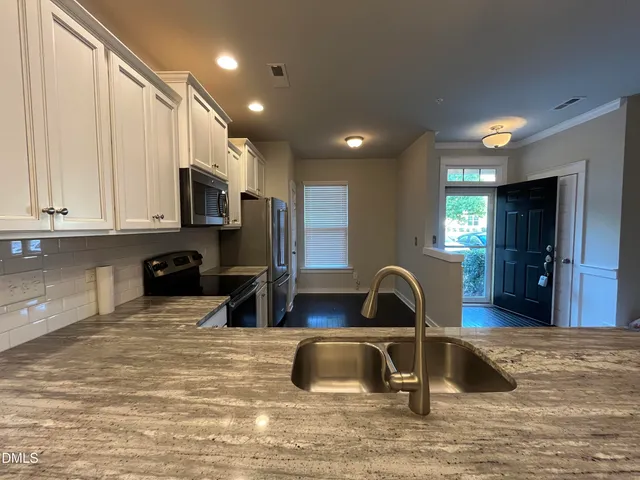 a kitchen with stainless steel appliances granite countertop a stove a sink and a microwave