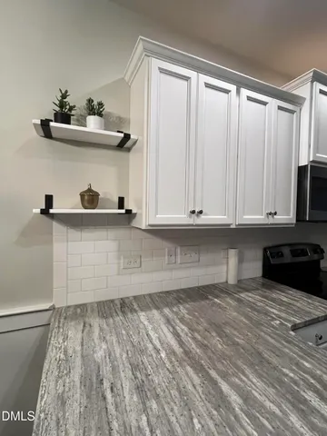 a view of kitchen with wooden floor and electronic appliances