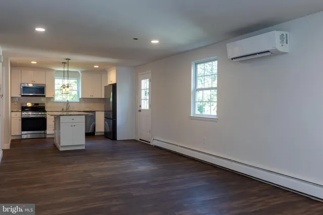 an open kitchen with a refrigerator and a stove top oven