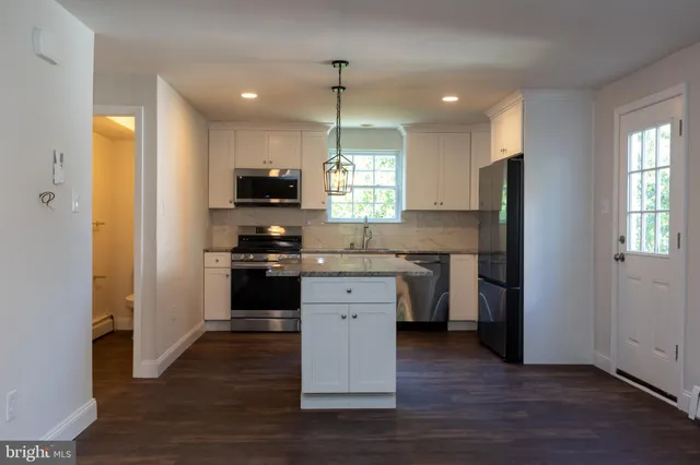 a kitchen with a refrigerator and a stove top oven
