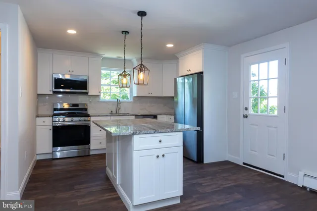 a kitchen with stainless steel appliances granite countertop a stove a refrigerator and a sink