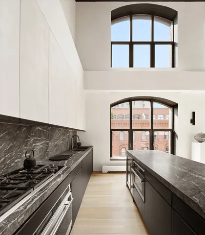 a kitchen with stainless steel appliances granite countertop a stove and a more cabinets