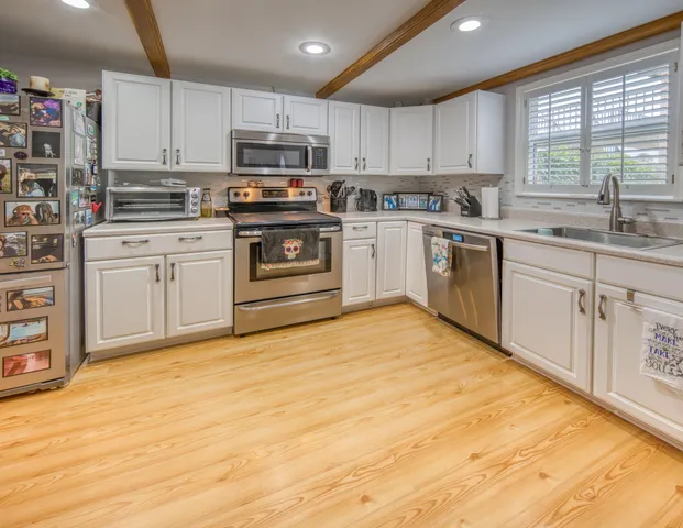 a kitchen with stainless steel appliances granite countertop a stove sink and cabinets
