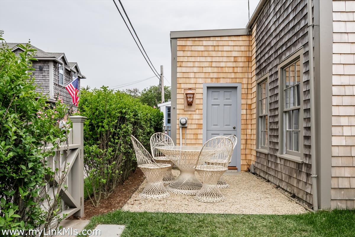 10 Centre Street Nantucket, MA 02554 - Photo 4 of 43 a front view of a house with outdoor seating and plants