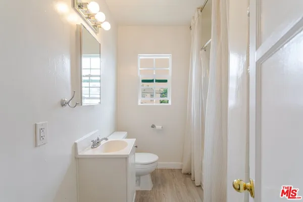 a bathroom with a toilet a sink and a window
