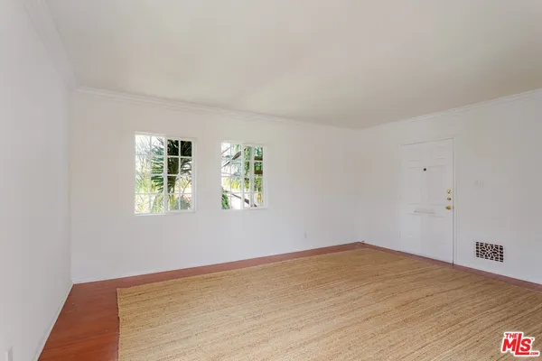 a view of wooden floor and windows in a room