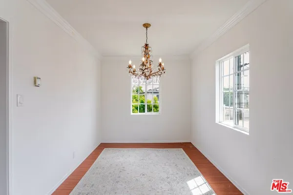 an empty room with windows and chandelier