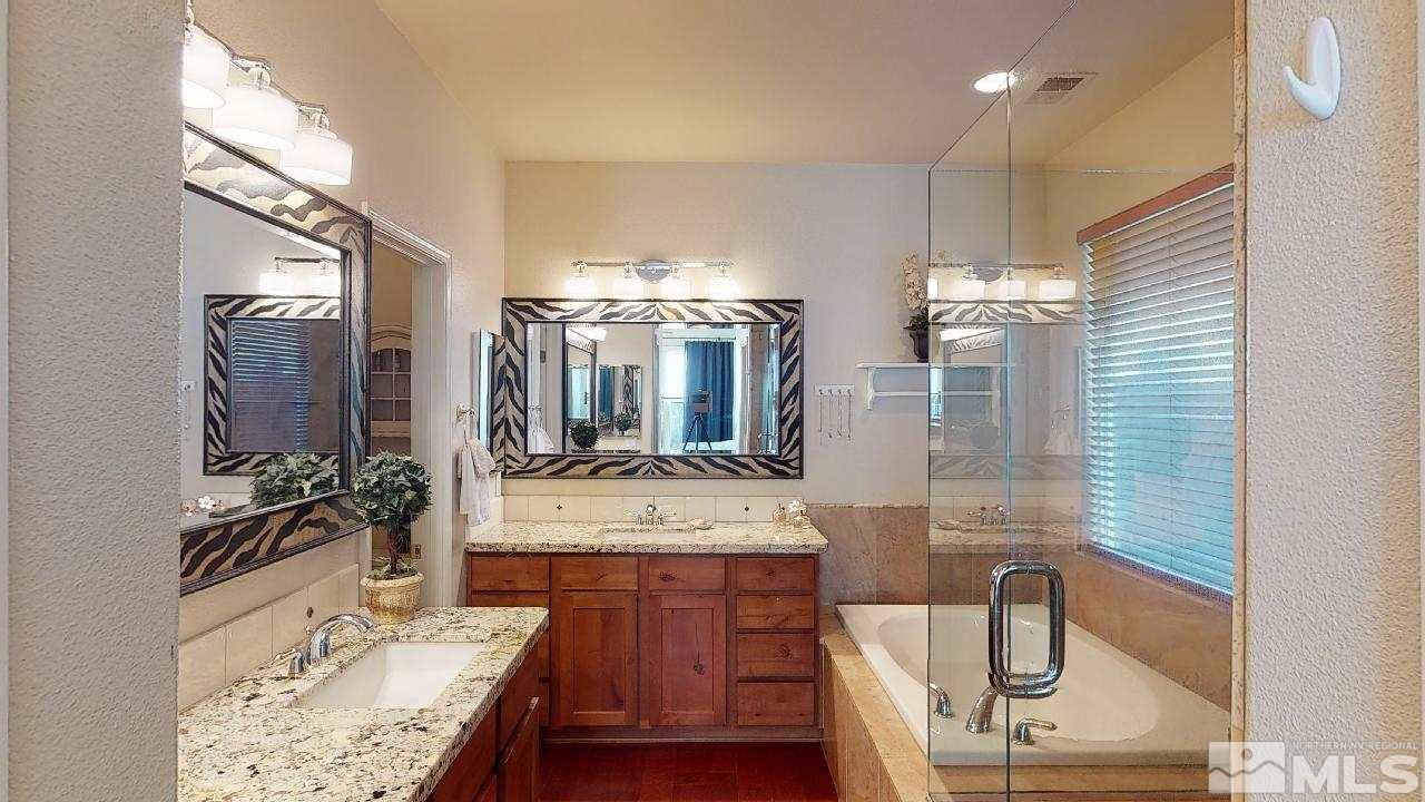 9565 Apache Rose Drive Reno, NV 89521 - Photo 11 of 25 a bathroom with a granite countertop sink a mirror and shower
