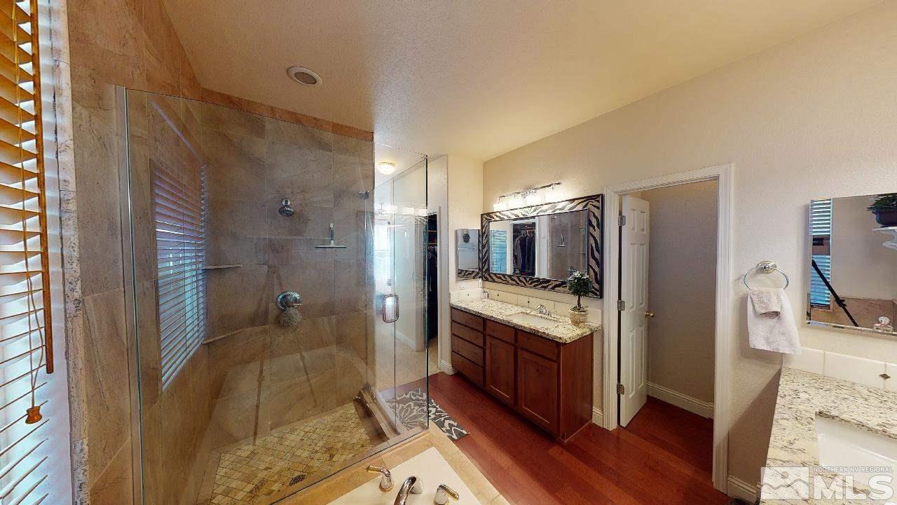 9565 Apache Rose Drive Reno, NV 89521 - Photo 12 of 25 a bathroom with a granite countertop sink a mirror and shower