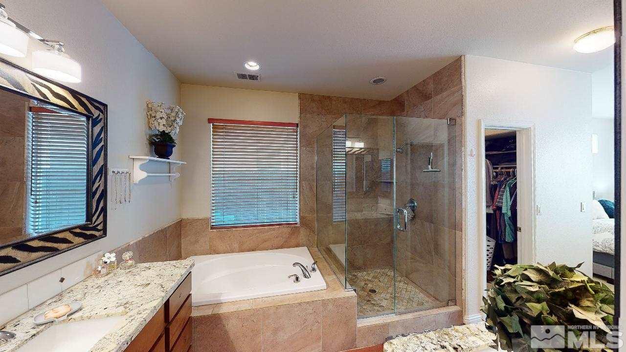 9565 Apache Rose Drive Reno, NV 89521 - Photo 13 of 25 a bathroom with a granite countertop tub sink a shower and a mirror