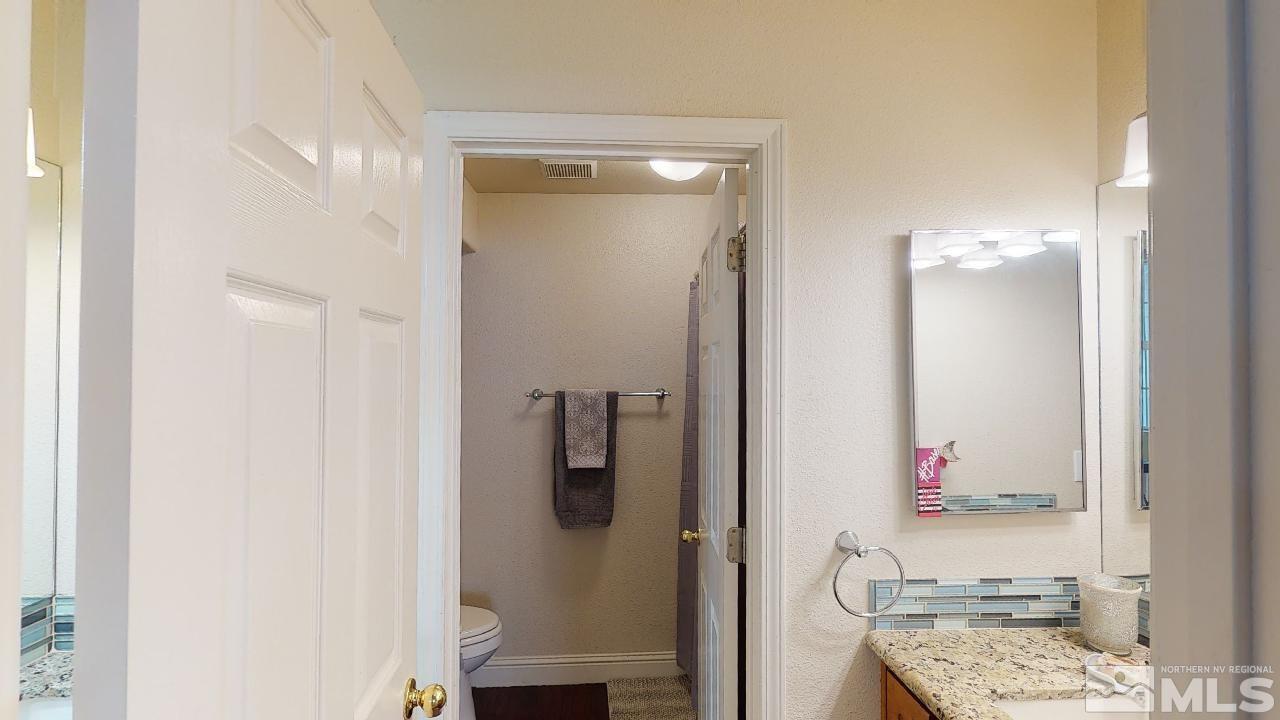 9565 Apache Rose Drive Reno, NV 89521 - Photo 18 of 25 a bathroom with a granite countertop shower a sink and a mirror