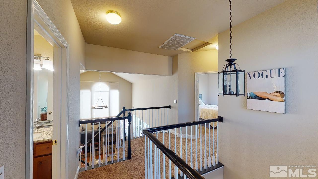 9565 Apache Rose Drive Reno, NV 89521 - Photo 22 of 25 a view of staircase with lots of frames on wall and wooden floor