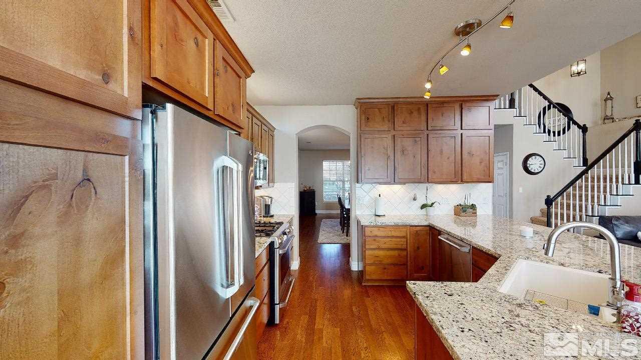 9565 Apache Rose Drive Reno, NV 89521 - Photo 6 of 25 a kitchen with stainless steel appliances granite countertop a refrigerator and a sink