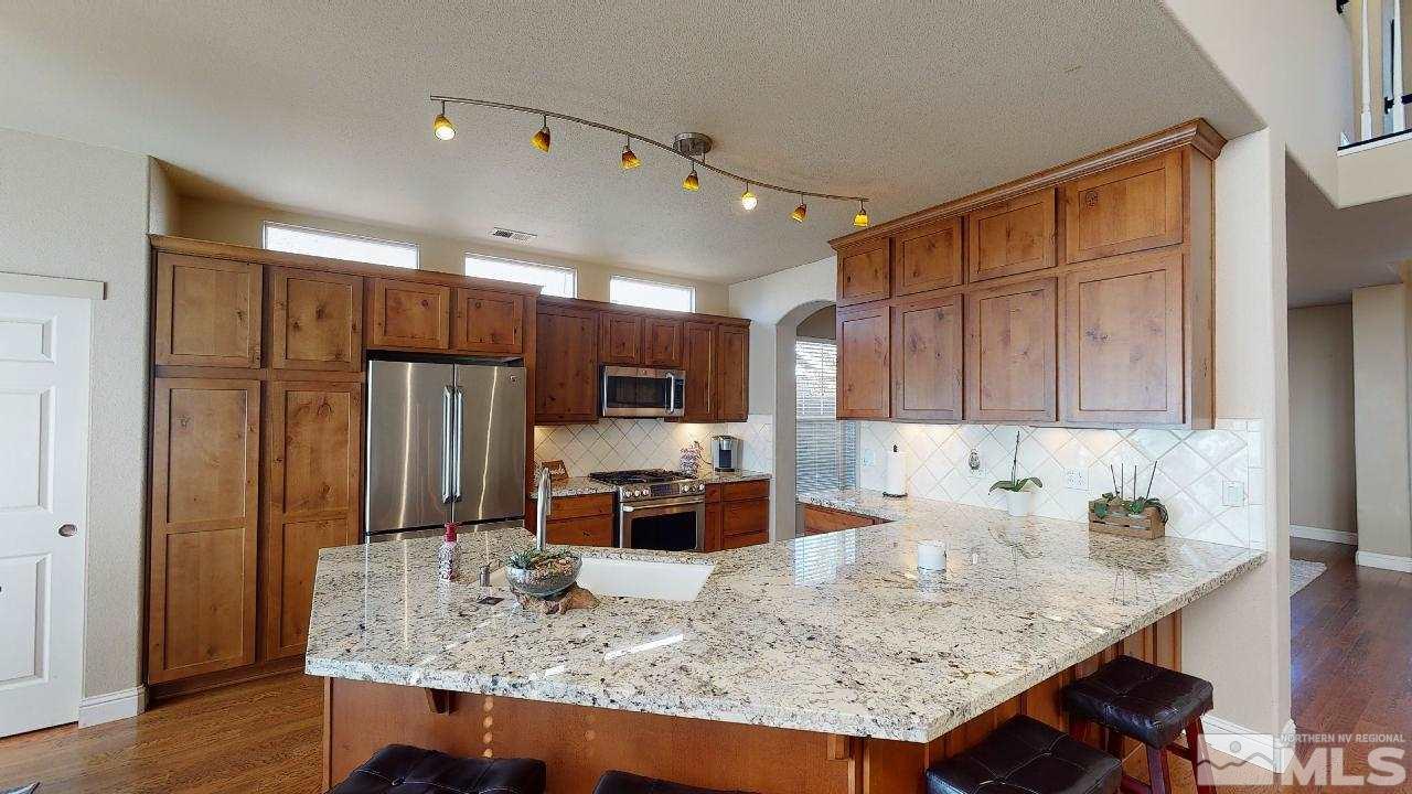 9565 Apache Rose Drive Reno, NV 89521 - Photo 7 of 25 a kitchen with stainless steel appliances granite countertop a sink refrigerator and cabinets