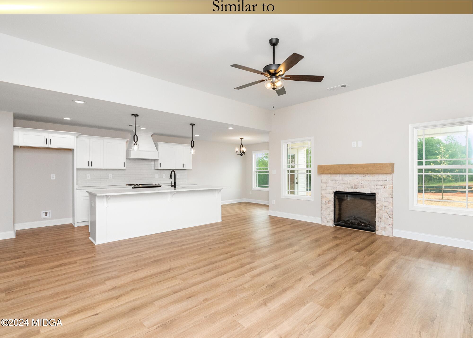 222 Overton Drive Perry, GA 31069 - Photo 4 of 18 a view of a kitchen with a fireplace a ceiling fan and wooden floor