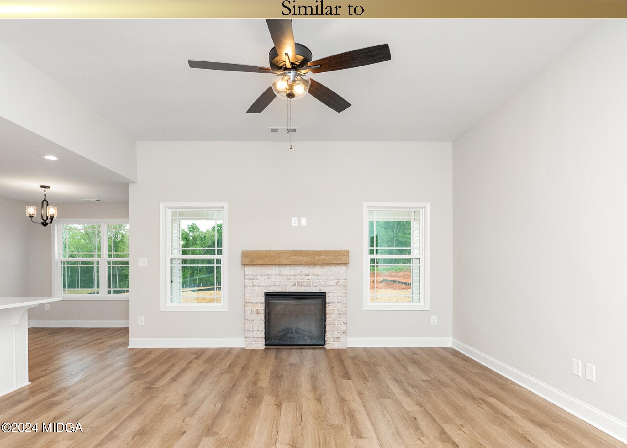 222 Overton Drive Perry, GA 31069 - Photo 5 of 18 an empty room with wooden floor fan and windows