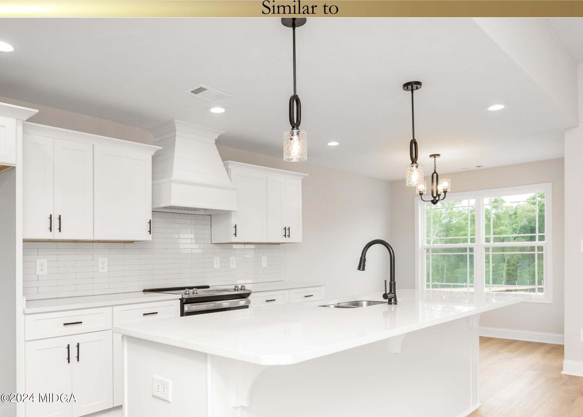 222 Overton Drive Perry, GA 31069 - Photo 10 of 18 a kitchen with stainless steel appliances granite countertop a sink a window and white cabinets