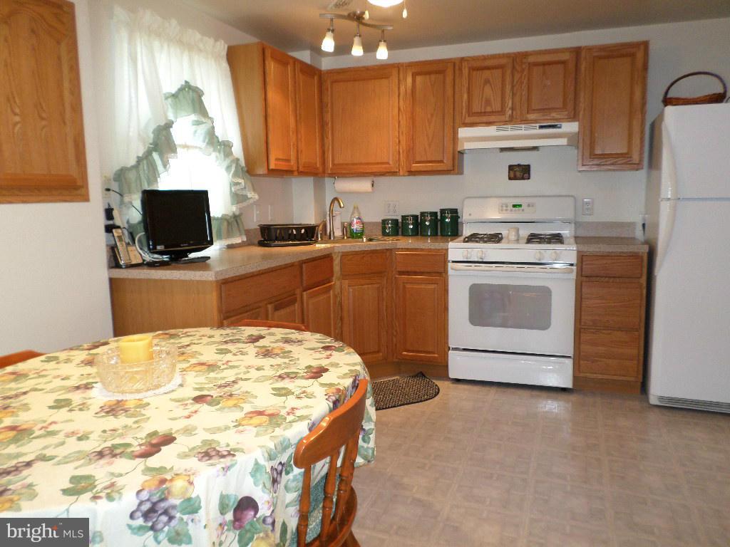 2824 Patapsco Road Finksburg, MD 21048 - Photo 5 of 29 a kitchen with a stove a sink and a refrigerator