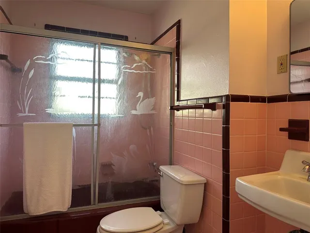 a bathroom with a toilet a sink and shower