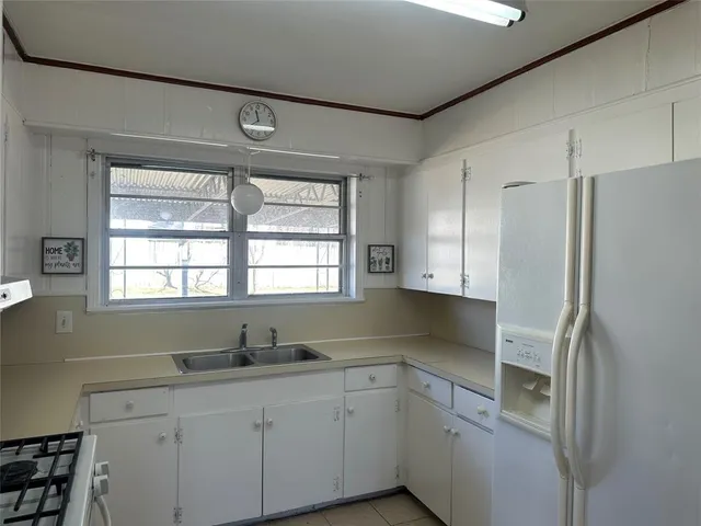 a kitchen with stainless steel appliances white cabinets and a window