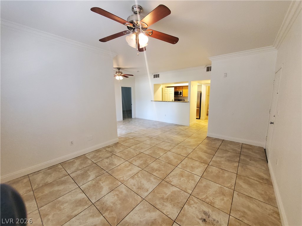7255 West Sunset Road, Unit 1167 Las Vegas, NV 89113 - Photo 13 of 15 Spare room featuring crown molding, light tile patterned floors, and ceiling fan