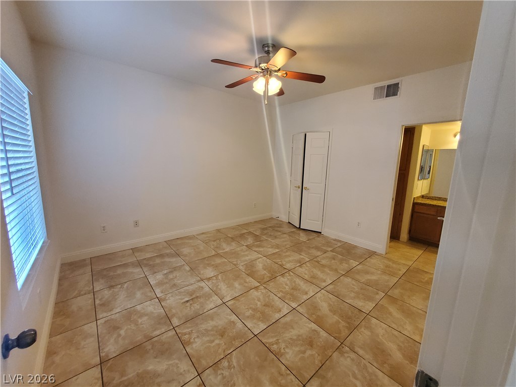 7255 West Sunset Road, Unit 1167 Las Vegas, NV 89113 - Photo 6 of 15 Unfurnished bedroom featuring ceiling fan, ensuite bathroom, and light tile patterned floors