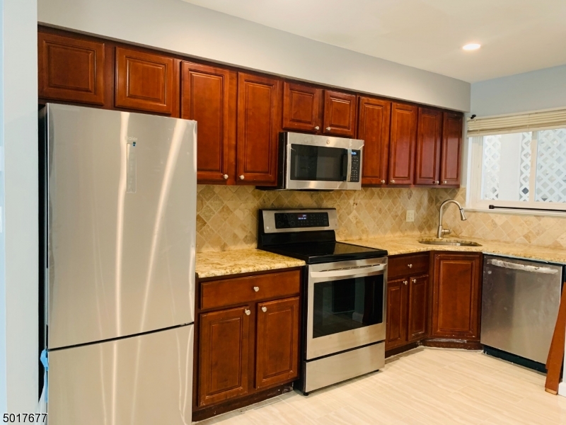 95 Park Street, Unit 3 Montclair, NJ 07042 - Photo 2 of 10 a kitchen with stainless steel appliances granite countertop a refrigerator stove a sink dishwasher and microwave