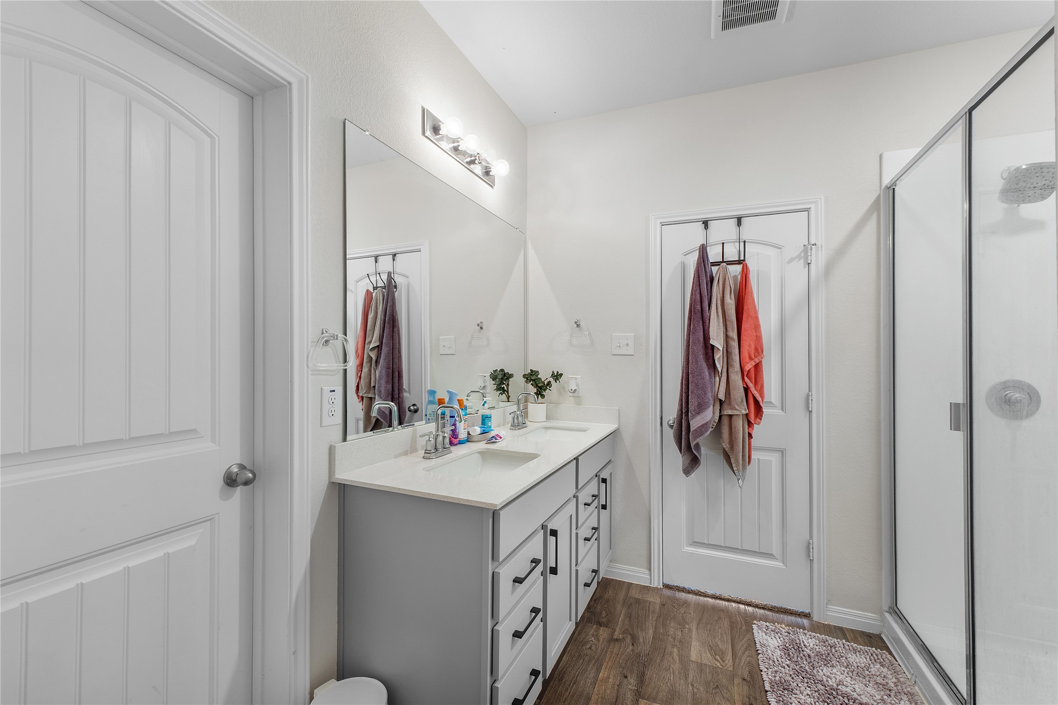 217 Evergreen Sumac Loop Kyle, TX 78640 - Photo 12 of 20 A well-appointed bathroom features a double vanity and a glass-enclosed shower, optimizing both utility and elegance.