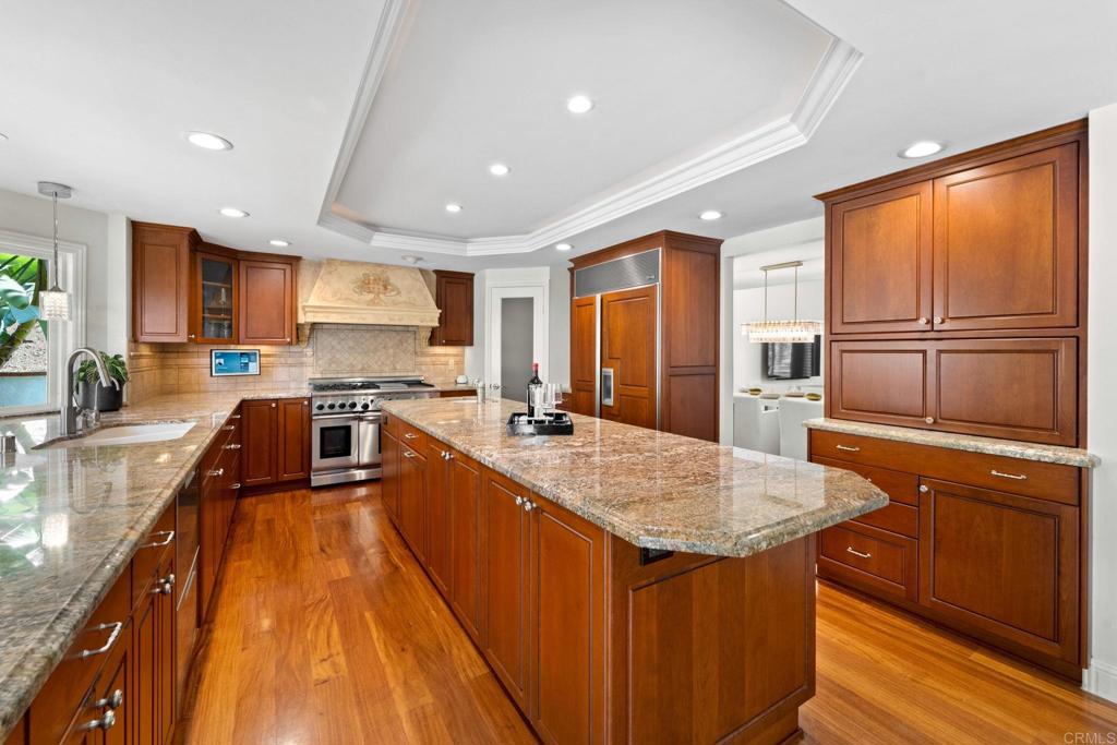 7056 Del Cerro Boulevard San Diego, CA 92120 - Photo 14 of 34 a large kitchen with kitchen island a large counter top space a sink stainless steel appliances and cabinets