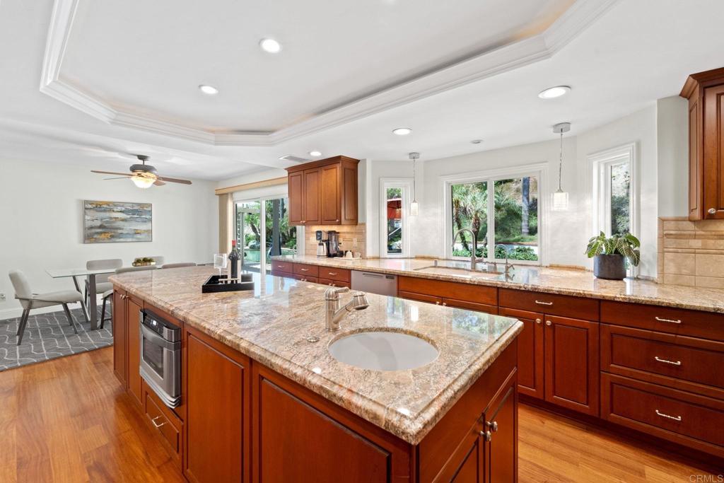 7056 Del Cerro Boulevard San Diego, CA 92120 - Photo 15 of 34 a kitchen with stainless steel appliances granite countertop a sink a counter space and wooden floor
