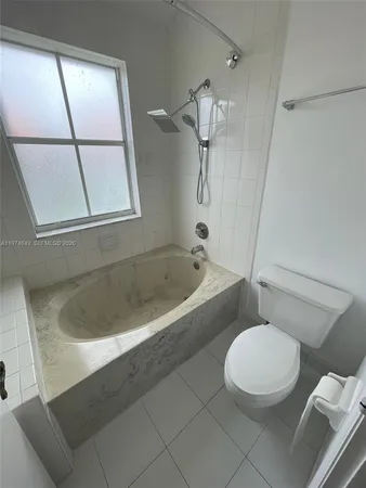 a white bath tub sitting next to a toilet