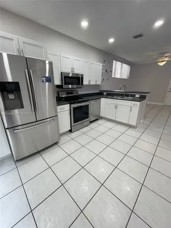 a kitchen with stainless steel appliances a refrigerator sink and microwave