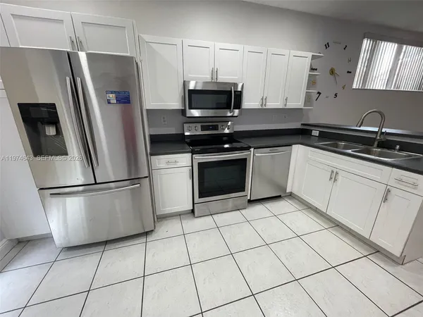 a kitchen with stainless steel appliances a refrigerator sink and microwave