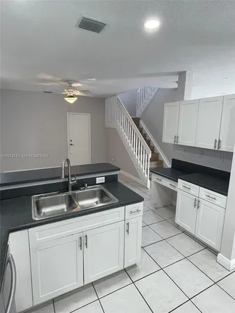 a kitchen with granite countertop a sink and a stove