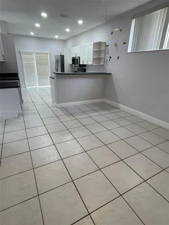 a view of a kitchen with kitchen island granite countertop appliances cabinets and a sink