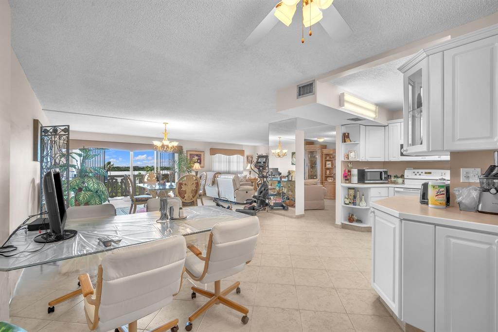 800 Northeast 195th Street, Unit 601 Miami, FL 33179 - Photo 17 of 35 a kitchen with stainless steel appliances kitchen island granite countertop a sink and cabinets