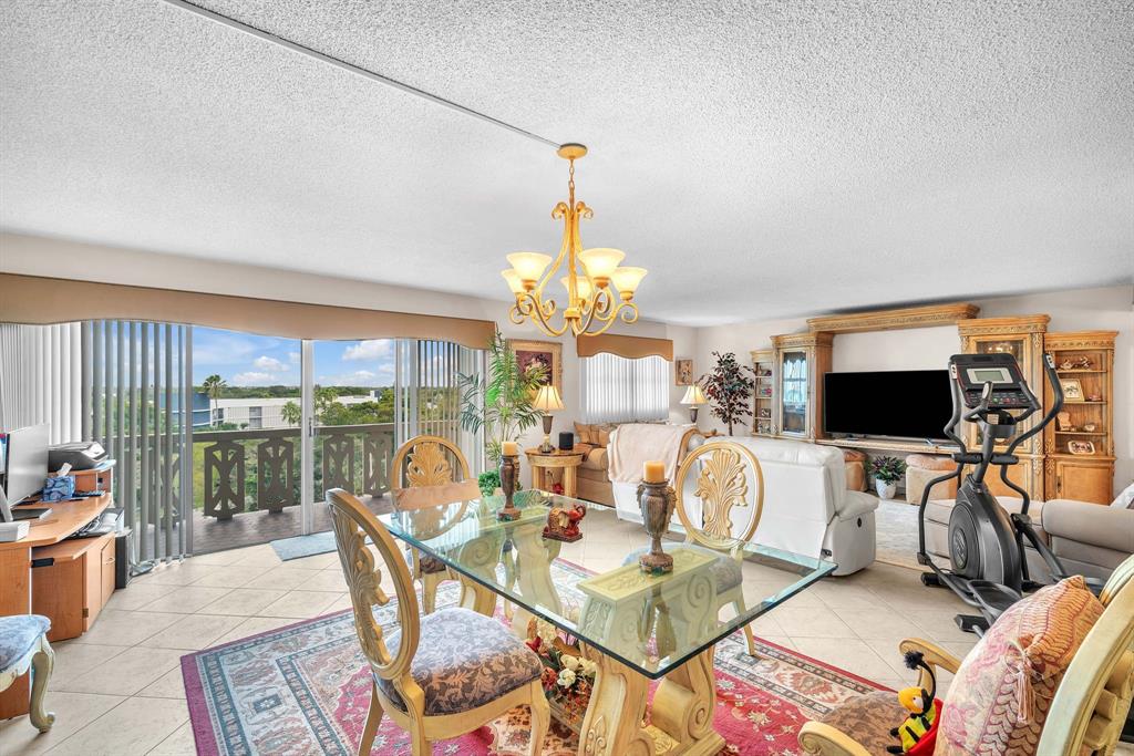 800 Northeast 195th Street, Unit 601 Miami, FL 33179 - Photo 4 of 35 a living room with furniture a flat screen tv and a floor to ceiling window