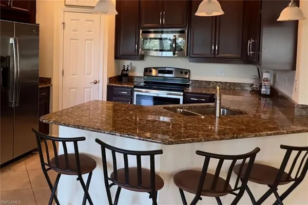 a kitchen with a dining table chairs and a refrigerator