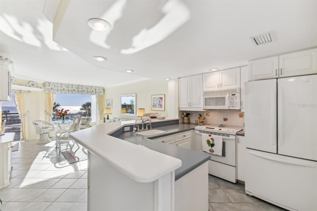 5000 Gasparilla Road, Unit BC203 Boca Grande, FL 33921 - Photo 3 of 34 a kitchen with stainless steel appliances granite countertop a sink stove and refrigerator